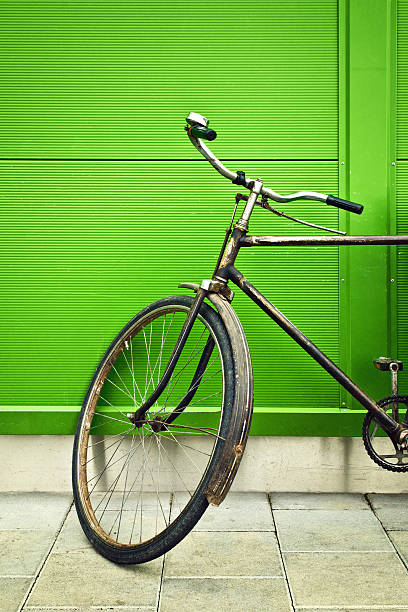 старый велосипед опираться на зеленая стена - bicycle wall green single object стоковые фото и изображения