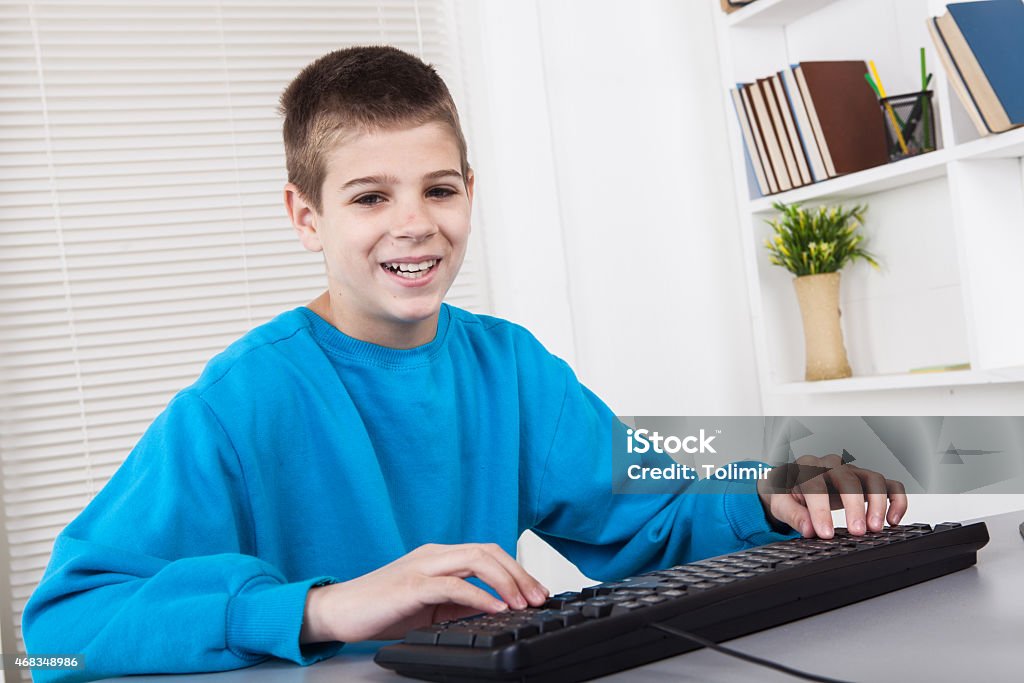 Working on computer Caucasian boy  with computer in room 10-11 Years Stock Photo