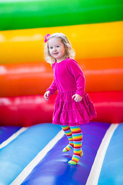 belle petite fille sauter et rebondir - inflatable slide sliding child photos et images de collection