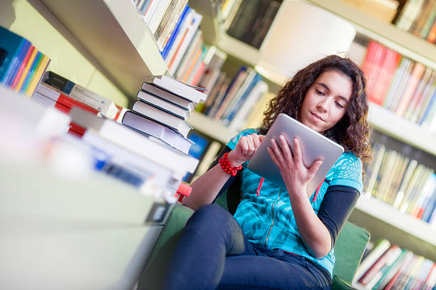 istock Young Woman with Digital Tablet in the Library 468351299