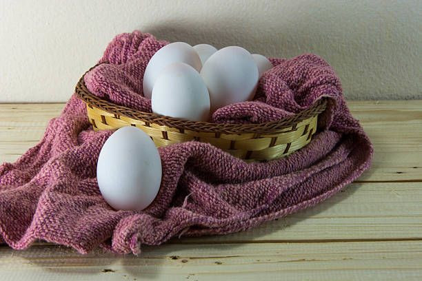 huevos frescos en un tejido cesta con red trapo de cocina. - eggs farm basket dairy farm fotografías e imágenes de stock
