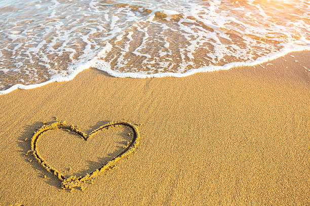 istock Hand drawn heart on beach sand over soft gold sunset. 468359192