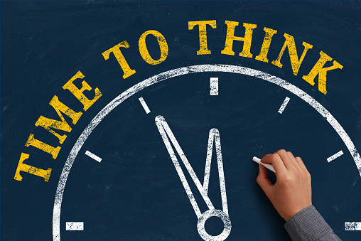 Businessman is drawing the concept of time to think on chalkboard.