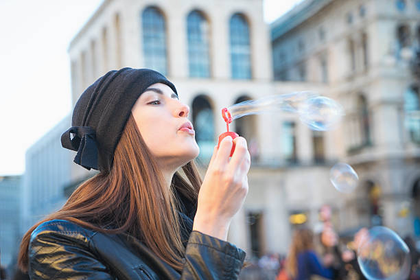 istock Young Woman Blowing Bubbles Outdoors In Urban Landscape 468362364