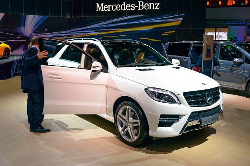 Brussels, Belgium - January 15, 2015: Mercedes Benz M-class ML 250 BlueTec SUV on display during the 2015 Brussels motor show. People in the background are looking at the cars.