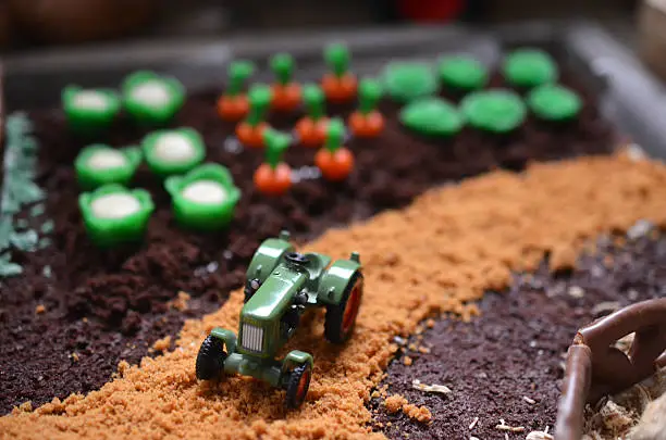 a little tractor on a cake looking like a farm