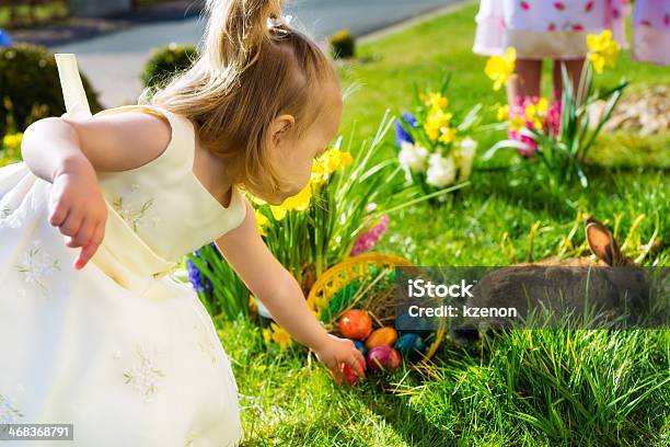 Children On An Easter Egg Hunt With Flowers And A Rabbit Stock Photo - Download Image Now