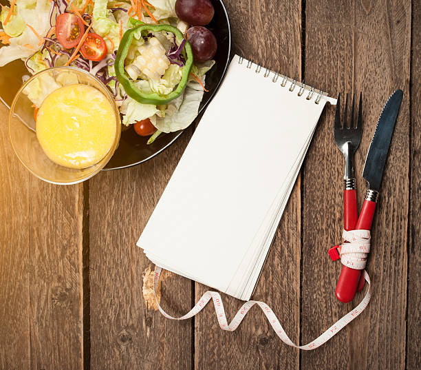 istock Fresh healthy salad and notepad on wooden table 468372496