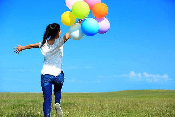 istock young asian woman with colored balloons 468375210