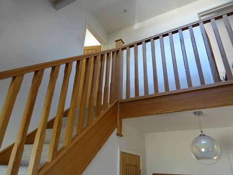 Image of modern, light-oak stair spindles / wooden staircase balusters, hallway