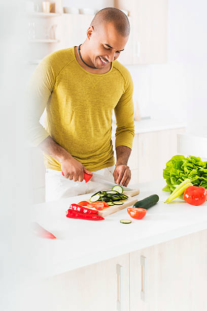 istock Smiling African American man preparing food in the kitchen. 468376548