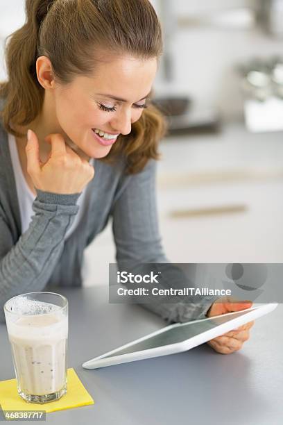 Happy Young Woman With Smoothie Using Tablet Pc Stock Photo - Download Image Now - Adult, Cheerful, Communication