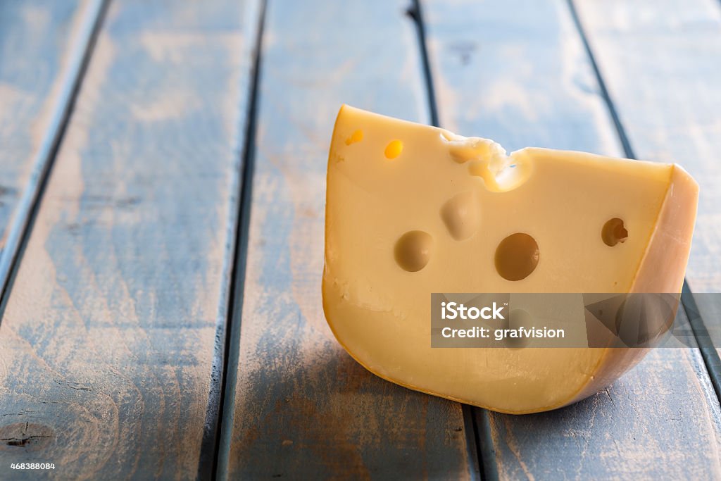 Cheese chunk Cheese chunk on painted wooden board 2015 Stock Photo