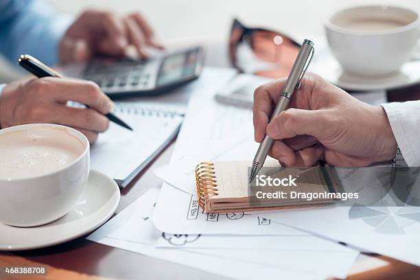 The Hands Of 2 Men Jotting In Notepads At Work Stock Photo - Download Image Now - 2015, Adult, Business