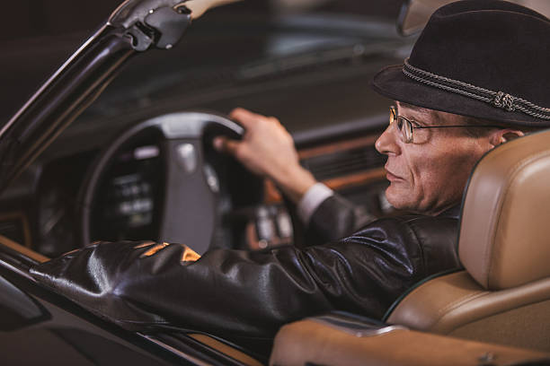istock Mature old fashioned man driving convertible car. 468388890