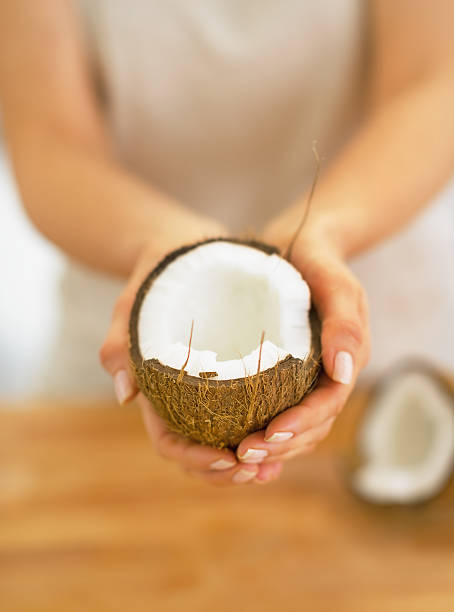 istock closeup on young woman showing coconut half 468393901