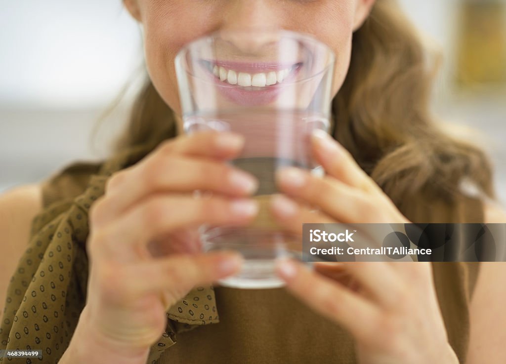 closeup on young housewife drinking water Closeup on young housewife drinking water Adult Stock Photo