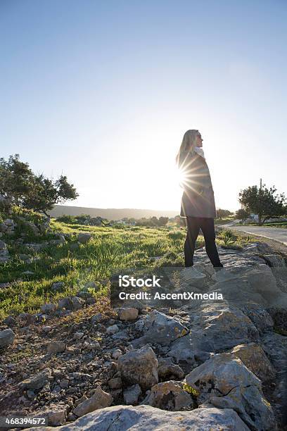 Woman Stands On Rock Wall Above Road Sunrise Stock Photo - Download Image Now - 2015, Adult, Agility