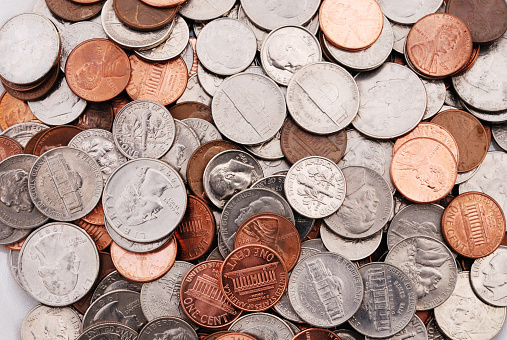 US coins in various denominations including pennies, nickels, dimes and quarters. Loose change.