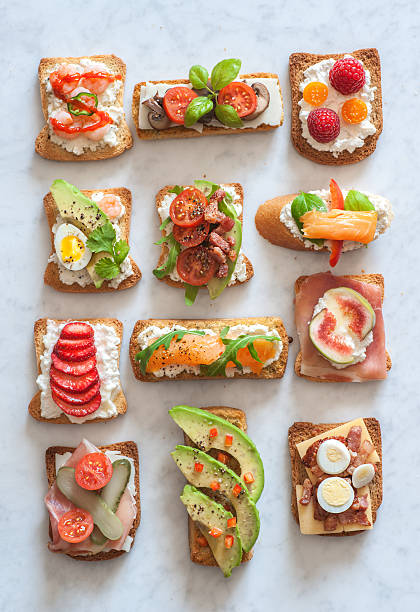 Toast An assortment of tartines, small open-faced sandwiches with various toppings both savory and sweet. crostini stock pictures, royalty-free photos & images