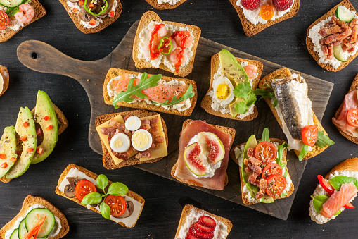 An assortment of tartines, small open-faced sandwiches with various toppings both savory and sweet.