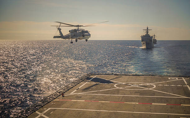 Helicopter landing on warship Helicopter landing on warship landing touching down stock pictures, royalty-free photos & images