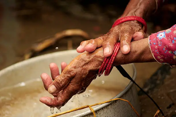 Elderly hands washing kitchen utensils