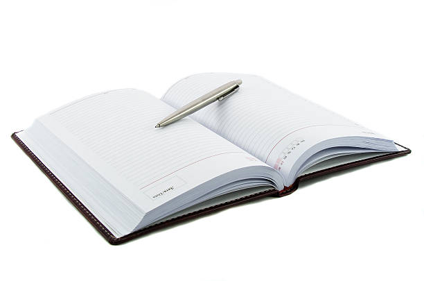 istock Close up noutbook and pen on it isolated over white 468408395
