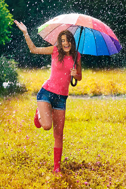 jovem e bela mulher diverte-te da chuva - rain women umbrella parasol imagens e fotografias de stock