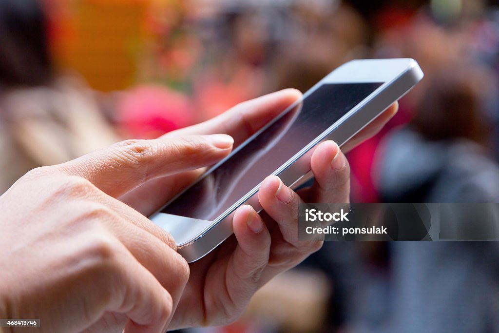 Close-up of a woman using smart phone with blurry background Close up image of Teenage girl text messaging on her phone 2015 Stock Photo