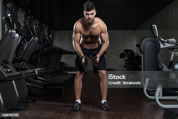 Handsome Man Exercising Shoulder With Dumbbells Stock Photo - Download Image Now - 18-19 Years, 2015, Adult