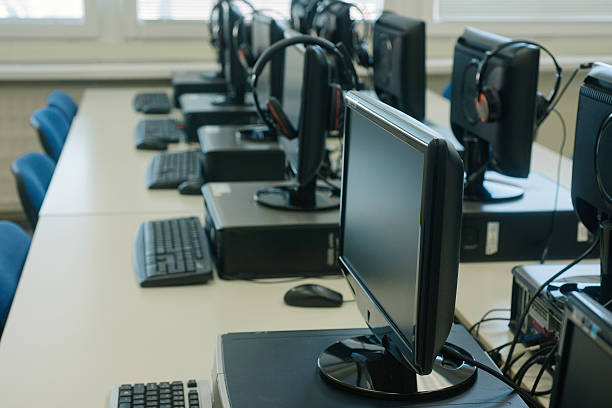 istock Computer room with many computers with headphones and keybords 468420494