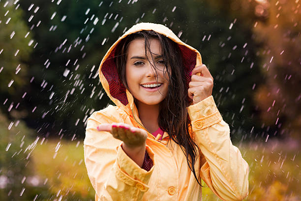 istock Pretty young woman in yellow raincoat 468421029