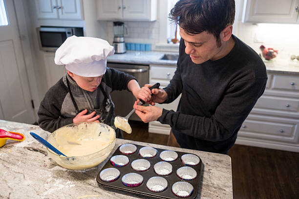 istock Cute boy with Down Syndrome baking with dad. 468421060