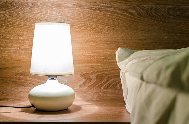 istock Night lamp on a nightstand illuminating the bed 468424104