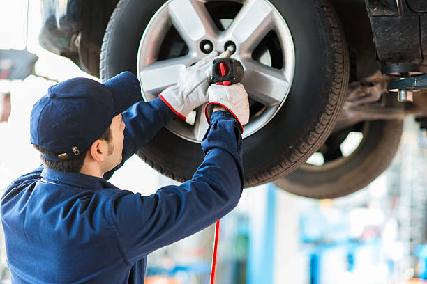 Mechanic changing a wheel on a car Mechanician changing car wheel in auto repair shop cycle vehicle photos stock pictures, royalty-free photos & images