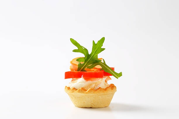 cheese and ham tartlet tartlet with cheese, ham, tomato and arugula leaves isolated on white background canape stock pictures, royalty-free photos & images