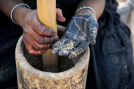 Tuareg women's hands grinding millet