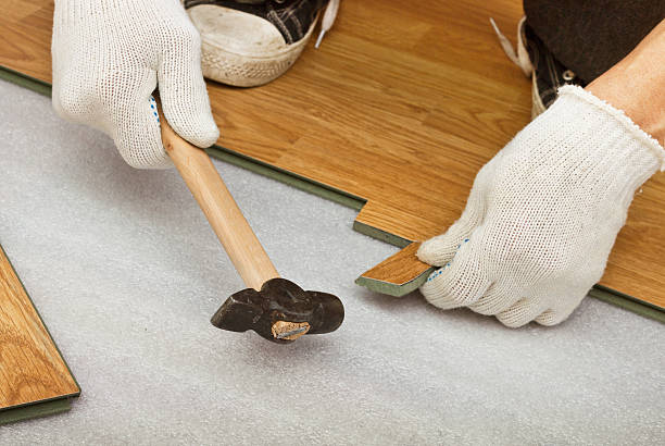 istock Carpenter works on laying laminate panels 468431627