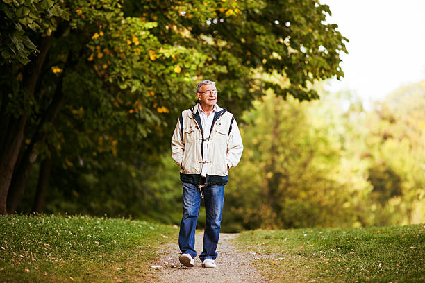 Senior man in jacket walking in the park