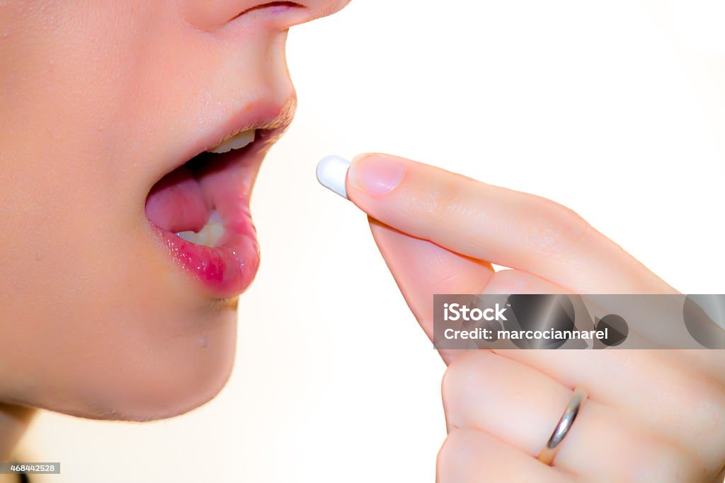 take a pill a woman takes a pill to cure 2015 Stock Photo