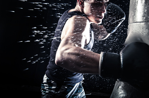 Young man boxing at the punching bag