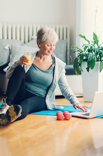 istock Mature Woman Exercising At Home Using Laptop. 468446460