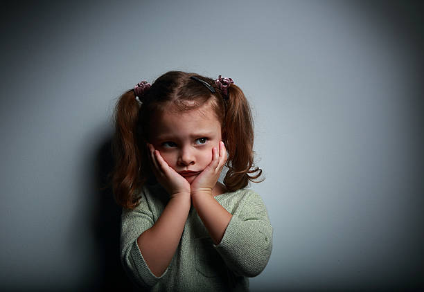 niño niña asustada con las manos cerca de la cara mirando - displeased child abandoned child abuse fotografías e imágenes de stock