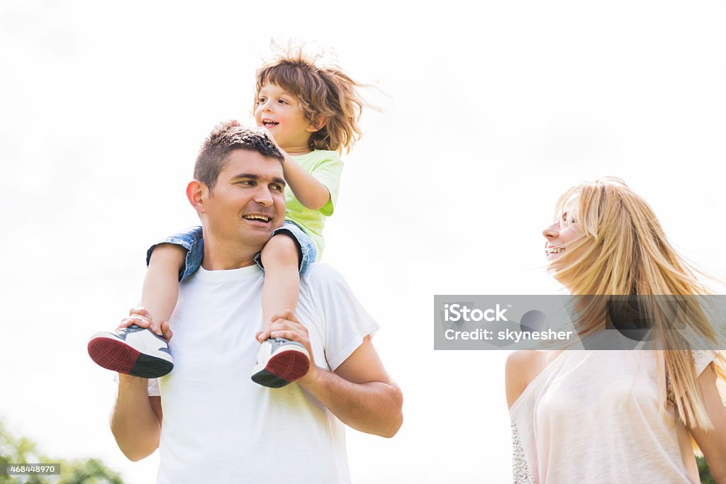 Cheerful family outdoors. Happy parents with their son in the nature. Father is carrying son on his shoulders. 2015 Stock Photo