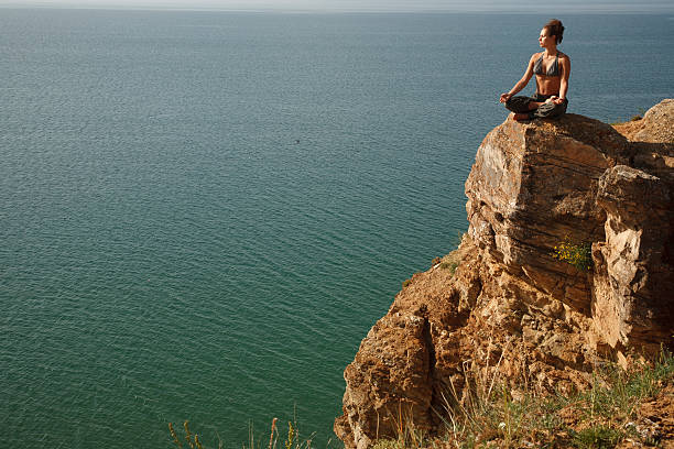 istock Real yoga instructor practicing on the rock near water line 468449246