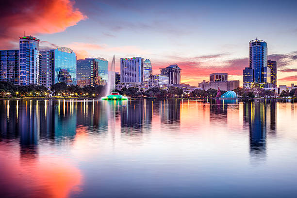 Orlando, Florida skyline at sunset  Orlando, Florida, USA skyline at Eola Lake. orlando florida photos stock pictures, royalty-free photos & images