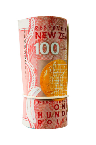 Roll of New Zealand banknotes, with $100 facing camera. Isolated on white and clipping path included.