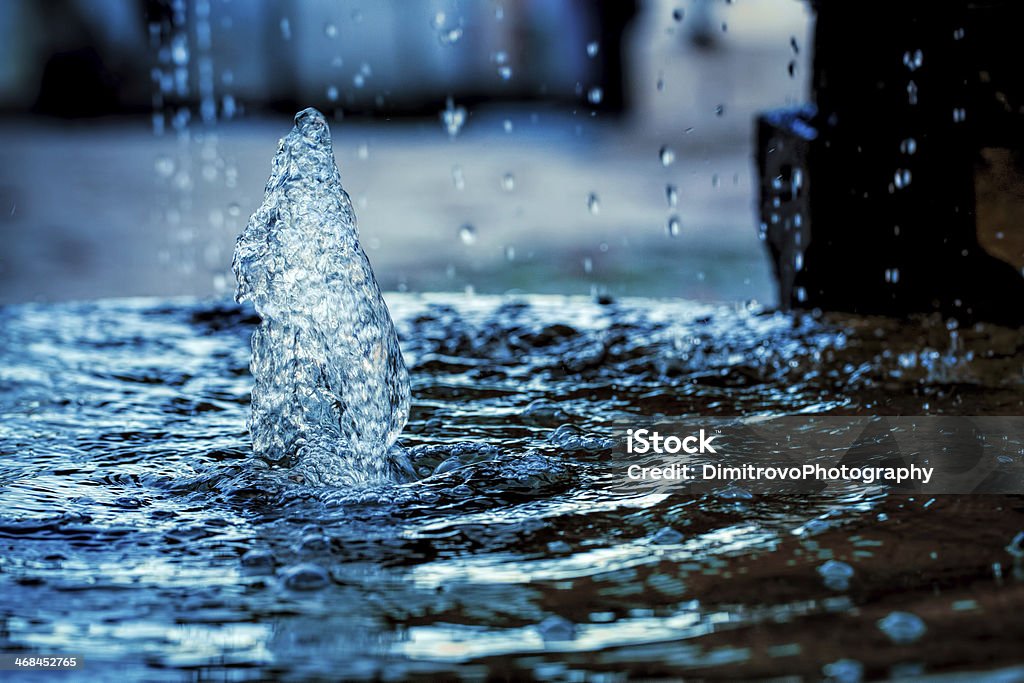 Water droplets falling into a puddle of water and splashing Cold fresh  water Blue Stock Photo