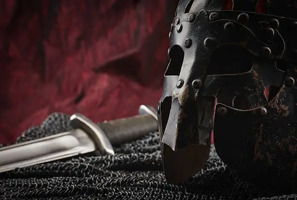 Medieval armour, helmet and sword, red canvas background